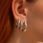 Chunky silver necklace styled with a scoop neckline and simple silver earrings