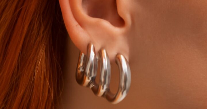 Chunky silver necklace styled with a scoop neckline and simple silver earrings