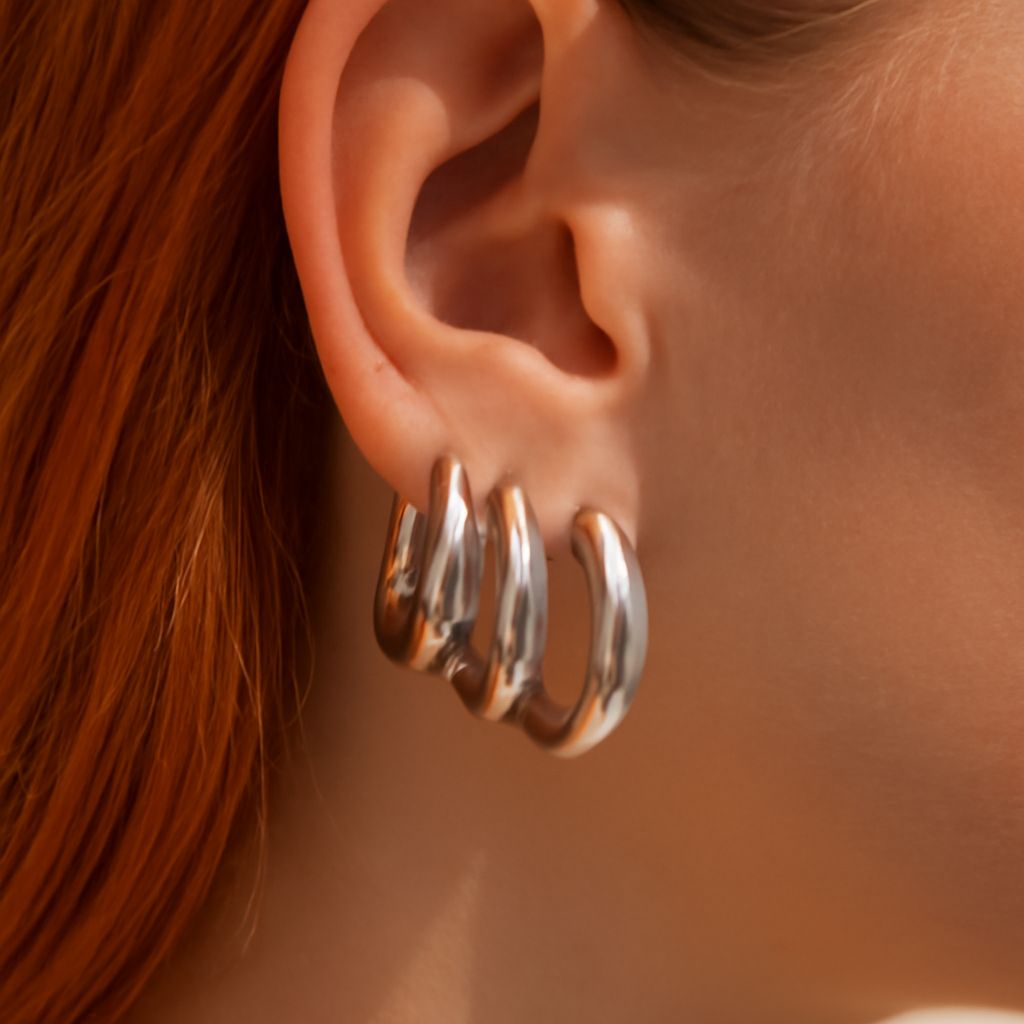 Chunky silver necklace styled with a scoop neckline and simple silver earrings