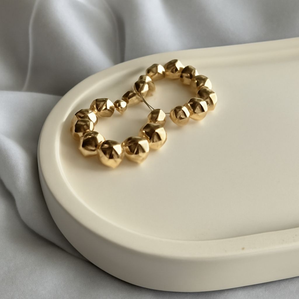 Gold huggie, threader, and bamboo earrings showing different lengths and hoop sizes