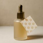 Sweet amber perfume oil beside an alcohol-based fragrance spray